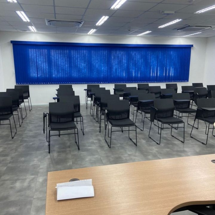 Persiana vertical de tecido azul em sala de treinamento, instalada pela EDD Cortinas